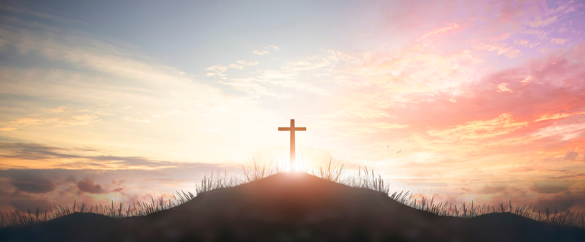 Holy concept: Silhouette cross on  mountain sunset background